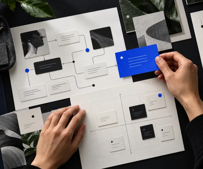 Hands arranging a redesigned product flow on a design board